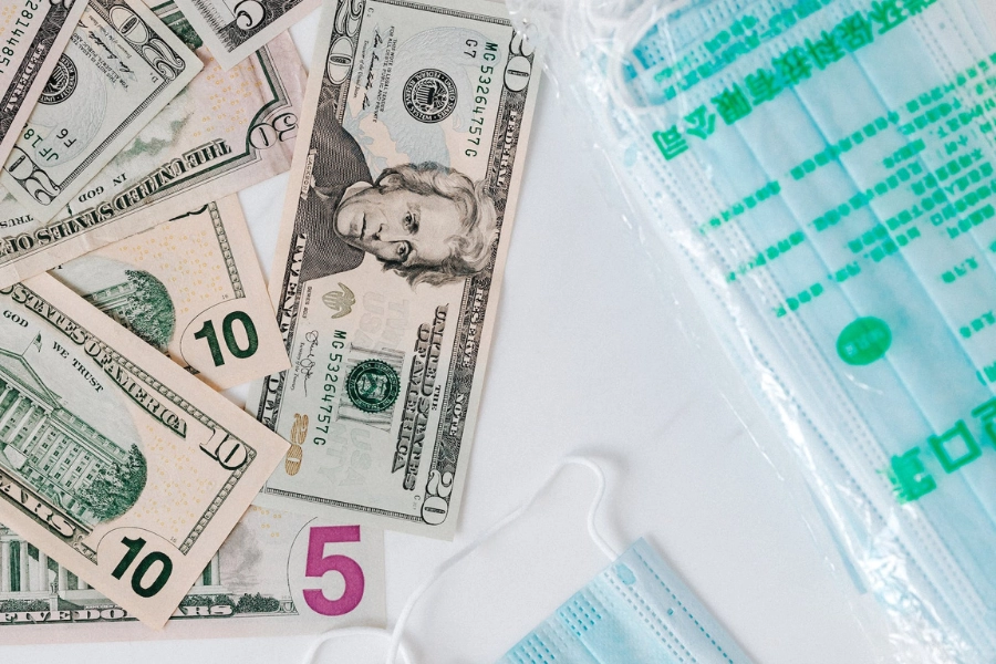 Money stacked next to medical equipment, indicating cost of the deductible in medical insurance